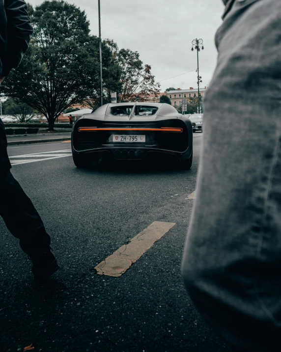 a man walking next to a car on the road