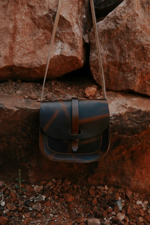 a handbag sitting on some rocks and stone