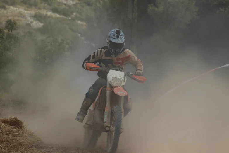 a dirt bike racer on a hill of dust