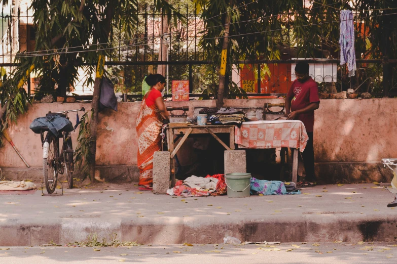 two people are outside cooking at the same table