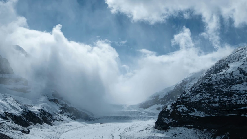 a bunch of fog in the mountains and snow in the ground