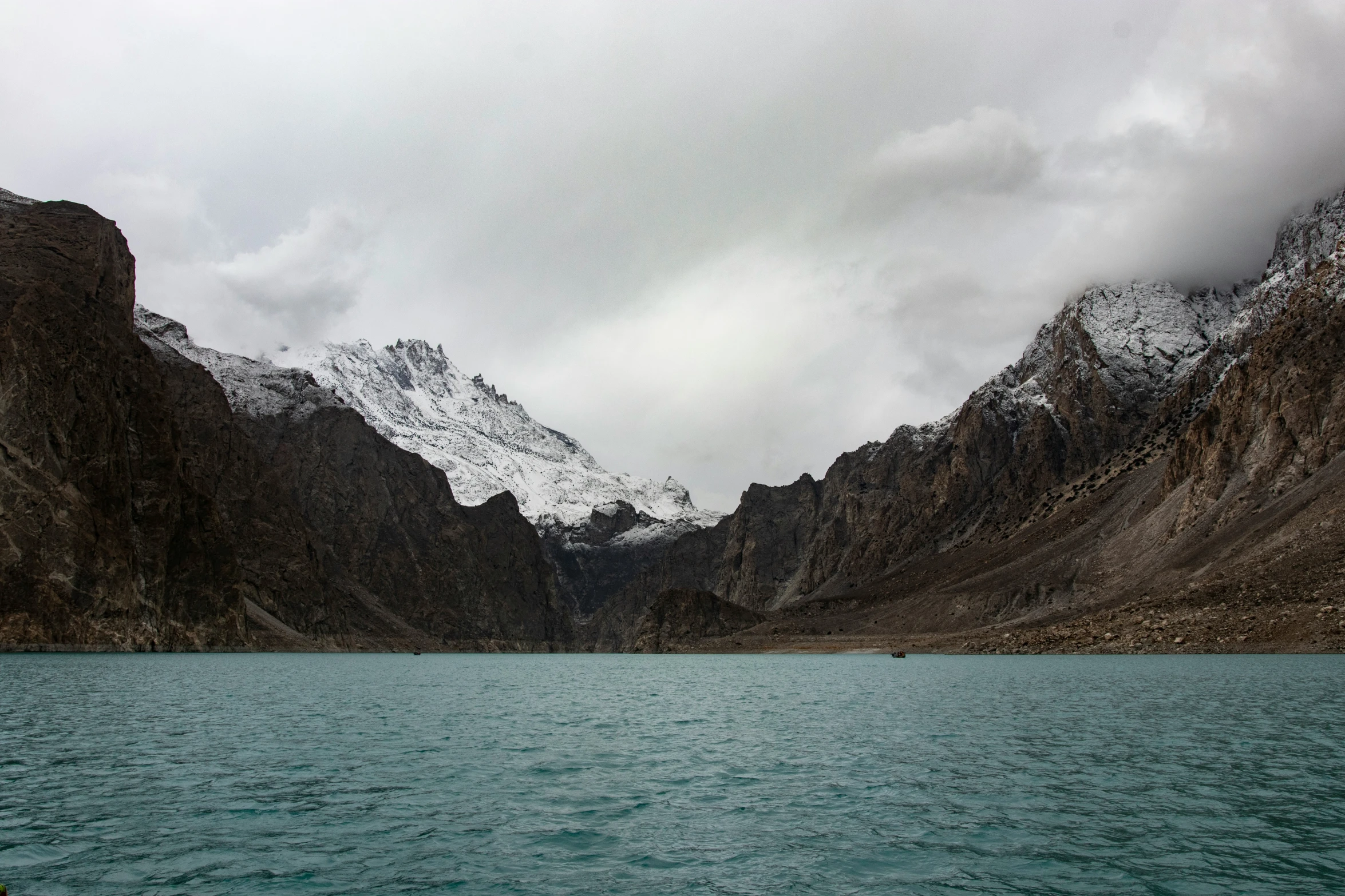 a small boat floating on top of a large lake