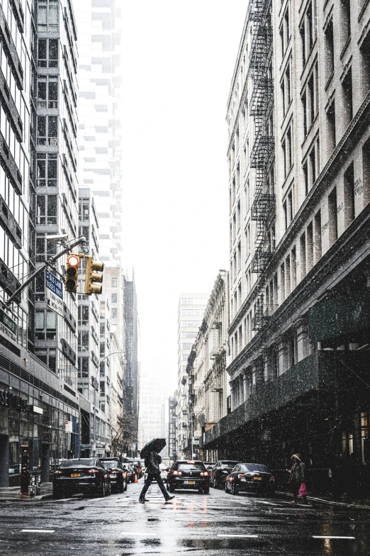 a man walking on the street at an intersection with heavy traffic