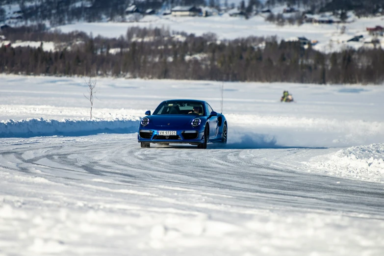 the car is driving in the snow with other cars