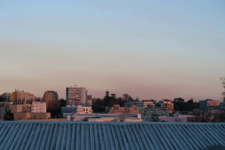 the sky is pink from the sky in front of some buildings