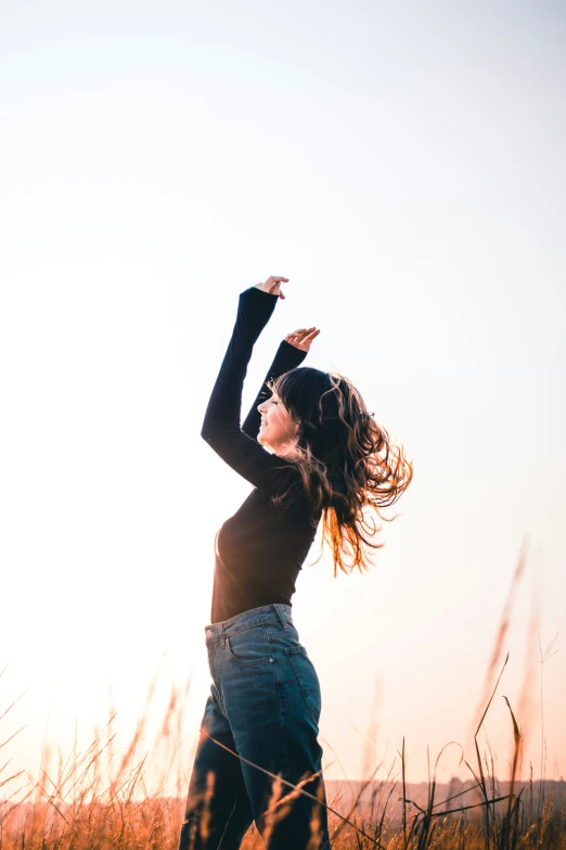 a girl reaching up into the sky with her arm