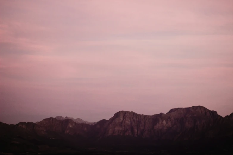 a very dark and cloudy sky is seen from a mountain