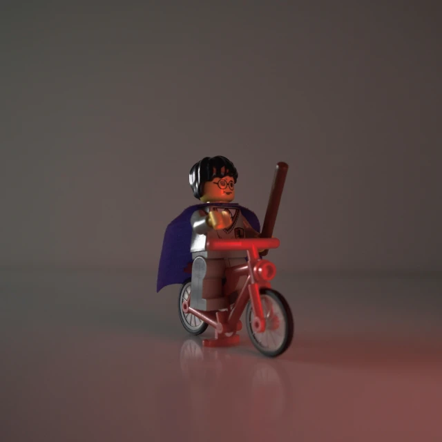 a small figurine is posed on a tiny bike