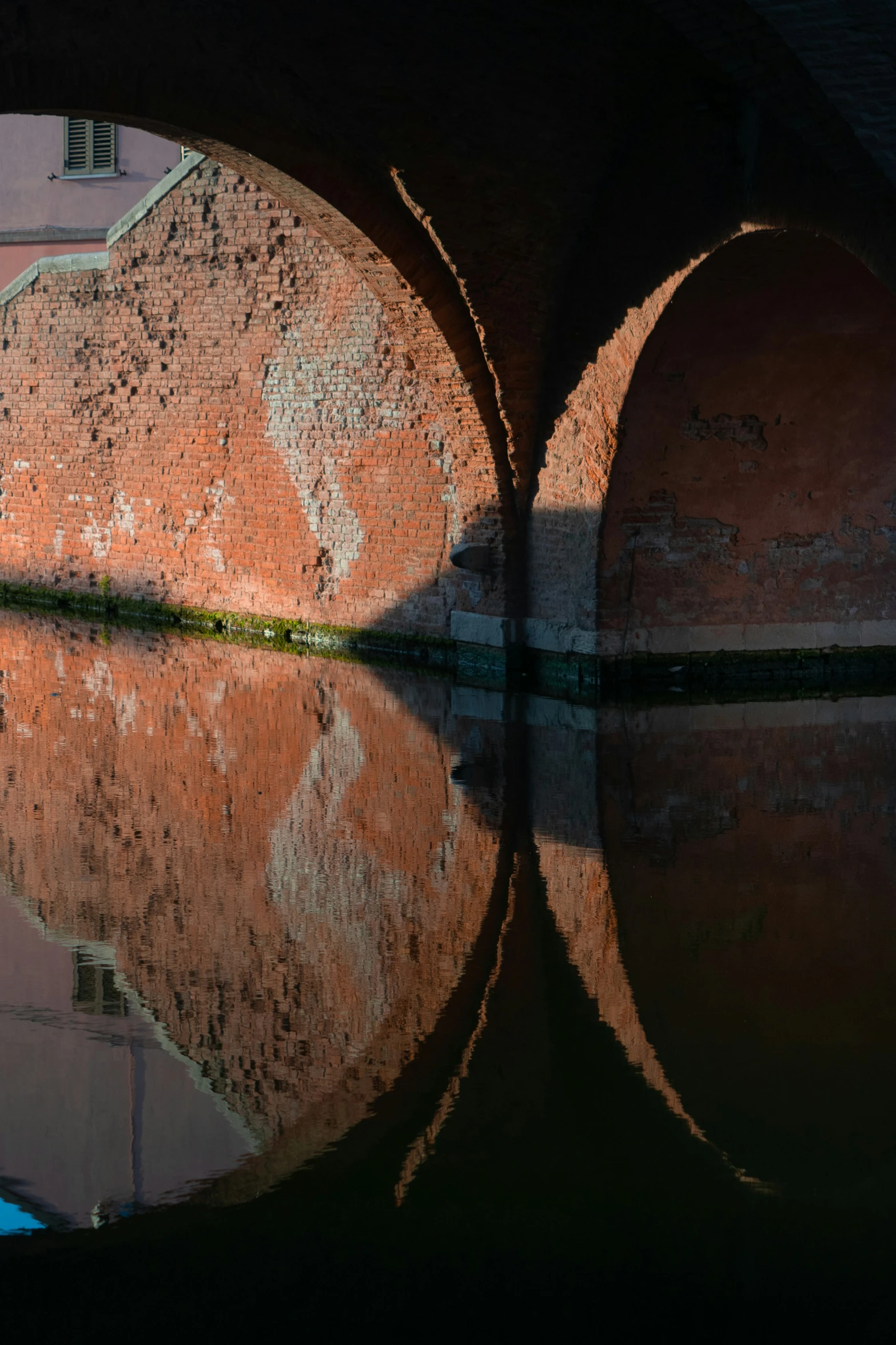 a view from underneath a stone bridge that has water underneath it