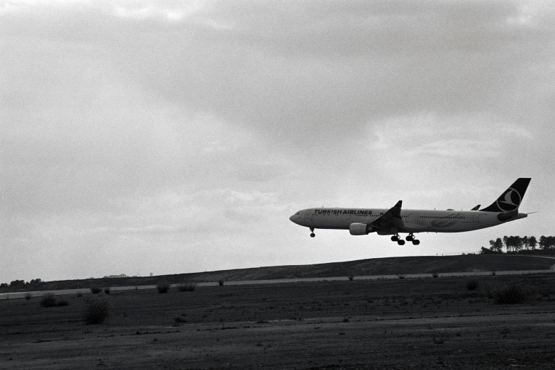 an airplane flies low in the cloudy sky