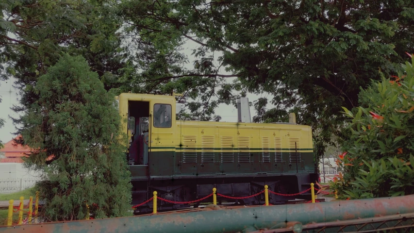 an old green train is traveling down the tracks