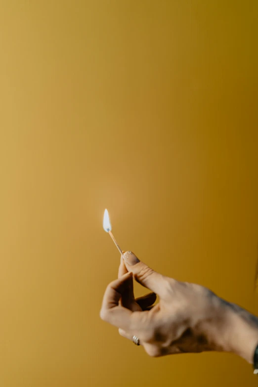 two hands hold a match light up