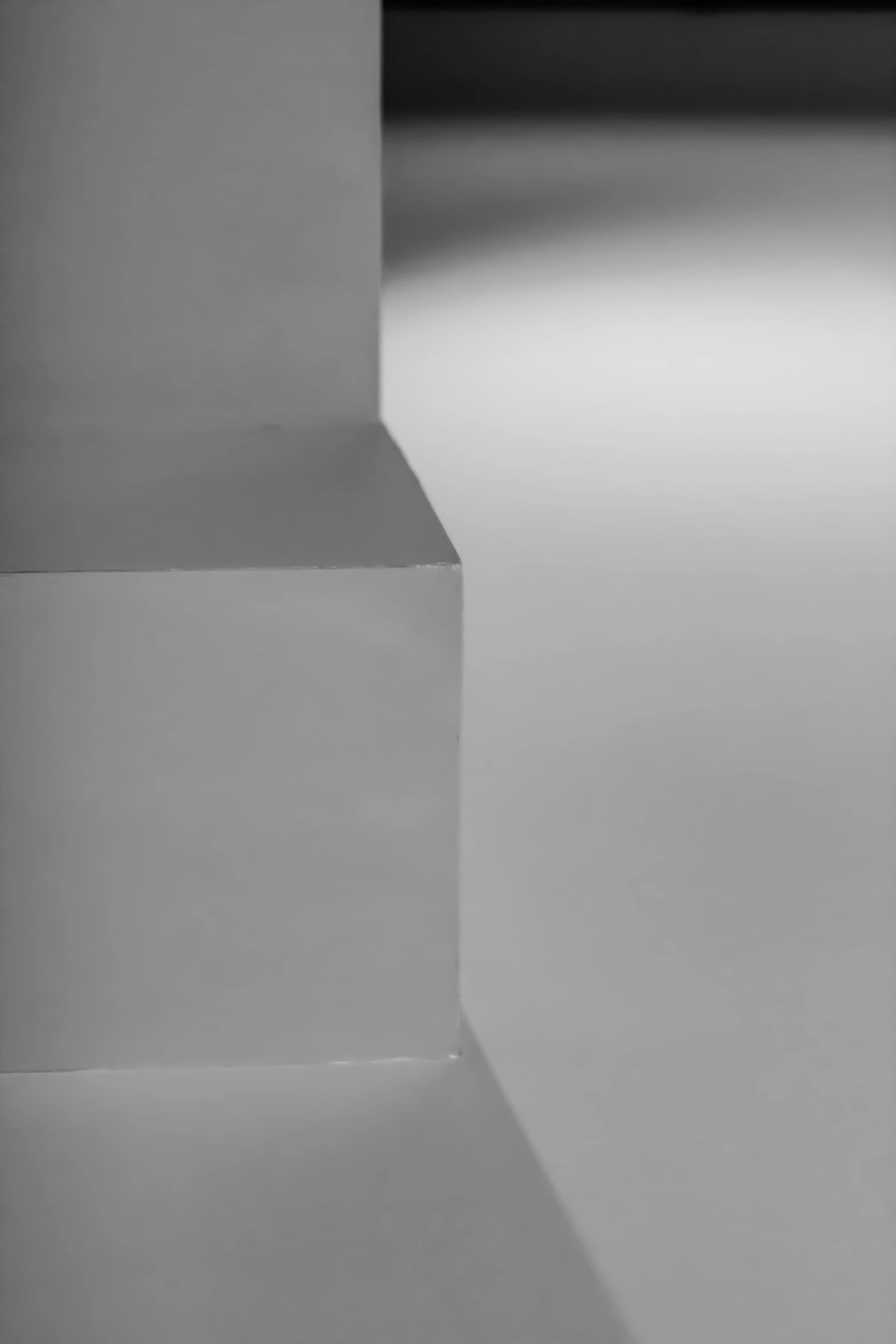 a black and white pograph of the corner of an empty wall