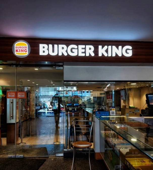 a burger king restaurant with a man walking in it