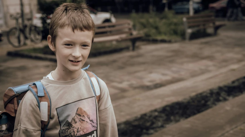 a  wearing a mountain shirt is standing in the parking lot