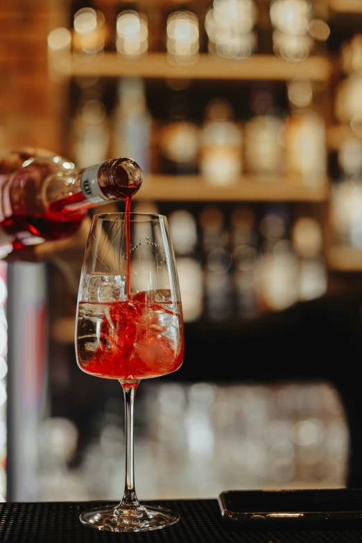 a bartender pouring red wine into a goblet