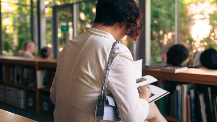 a woman sitting at a table in front of books