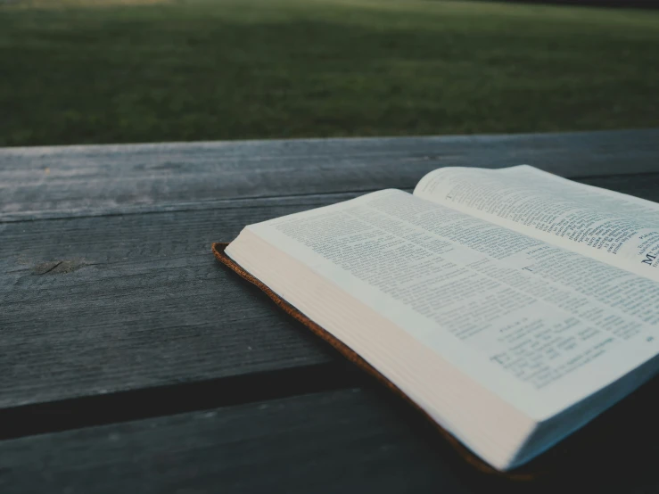 an open book that is sitting on a bench