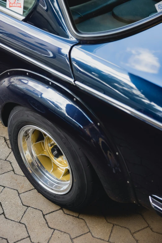 an old blue car with shiny yellow wheel arches