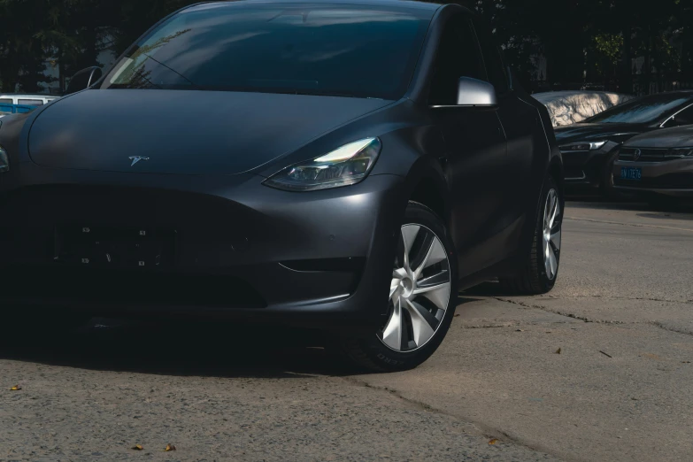 a black electric car is parked in a lot