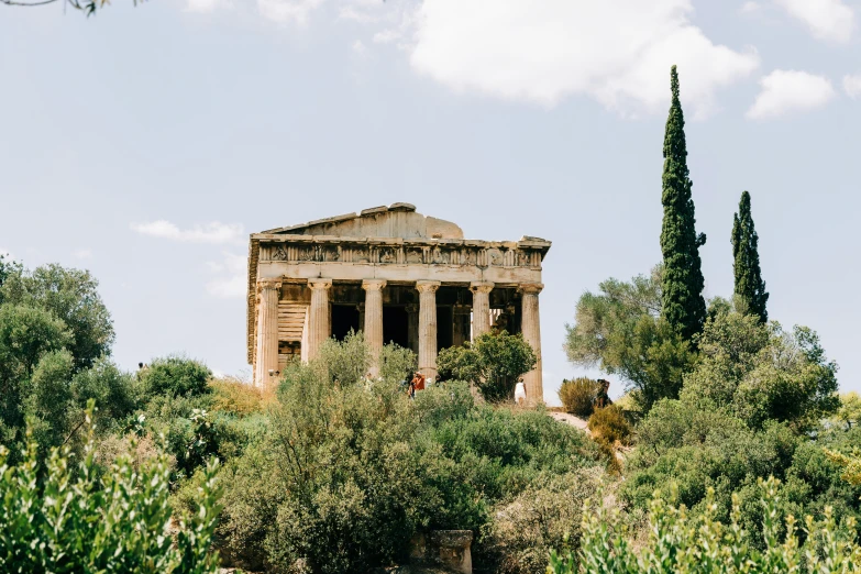 the ruins of the greek temple are visible among trees