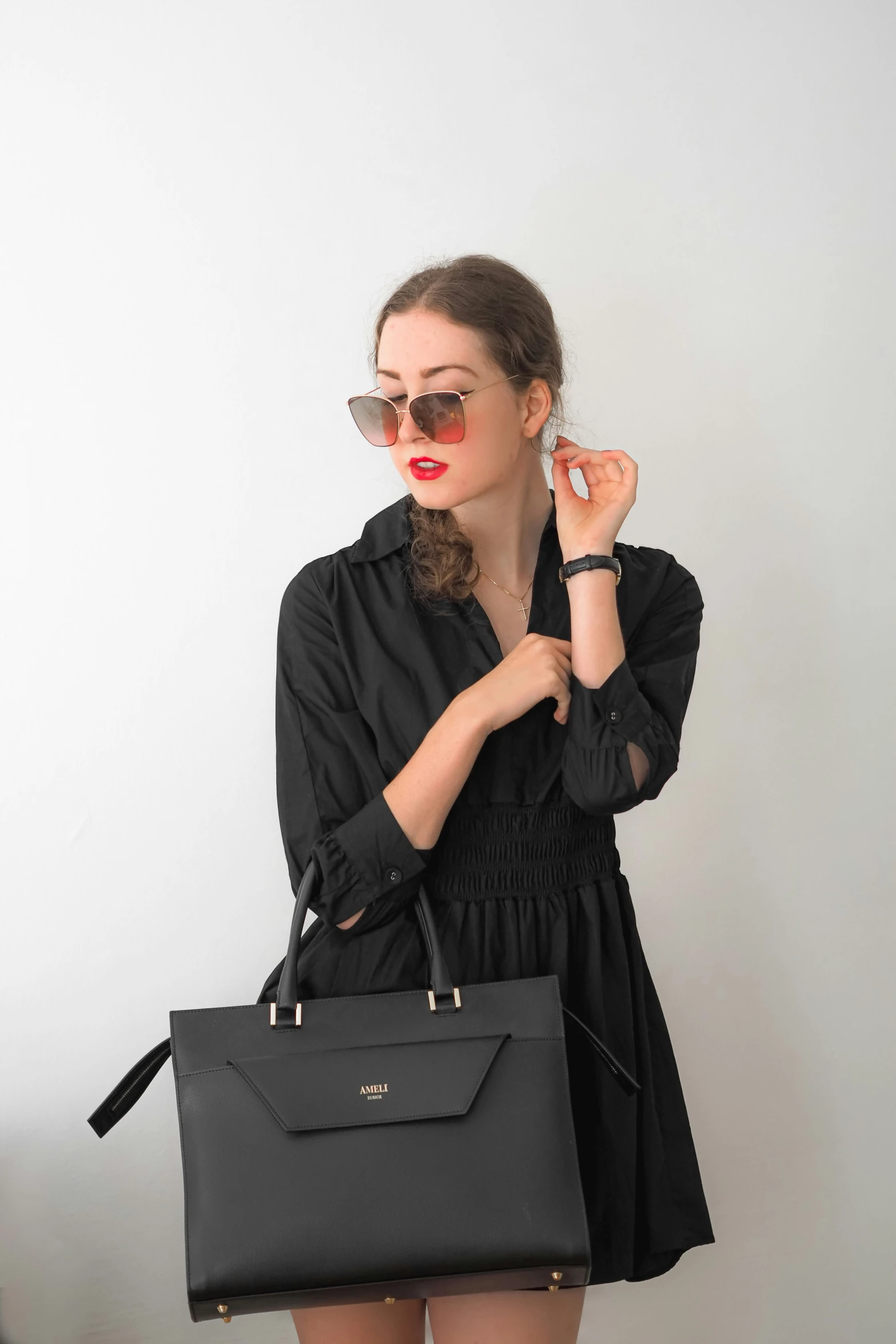 a girl is posing with a handbag