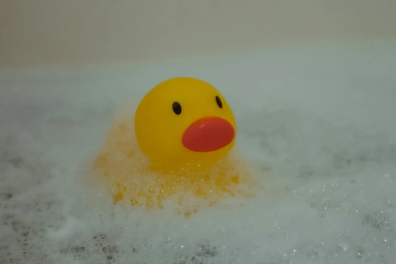 a yellow rubber duck in some water and foam