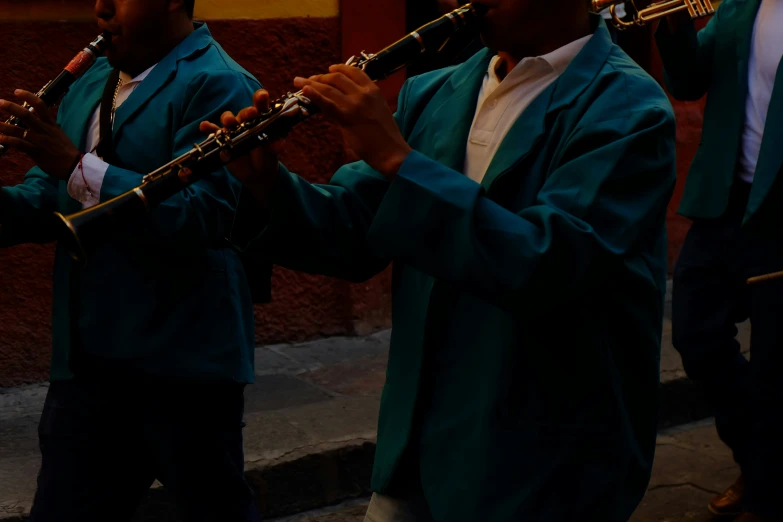 some men in blue coats are playing flutes