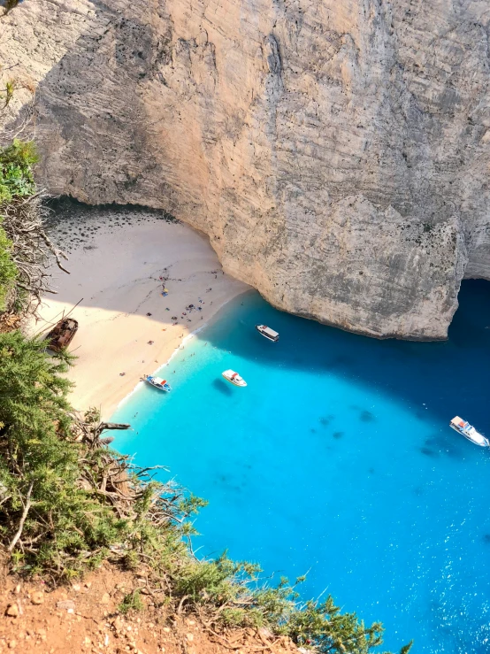 the sandy beach at the bottom of a mountain near a body of water