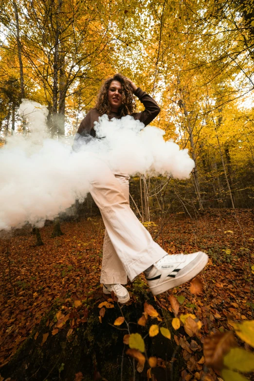 a woman is wearing white smoke while standing on an acrobats stump