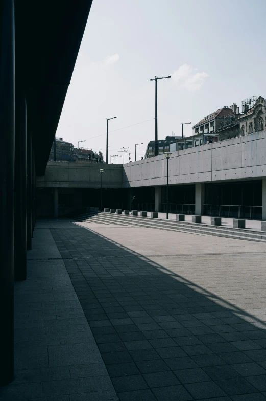 an empty street near some bridge buildings and a sky line