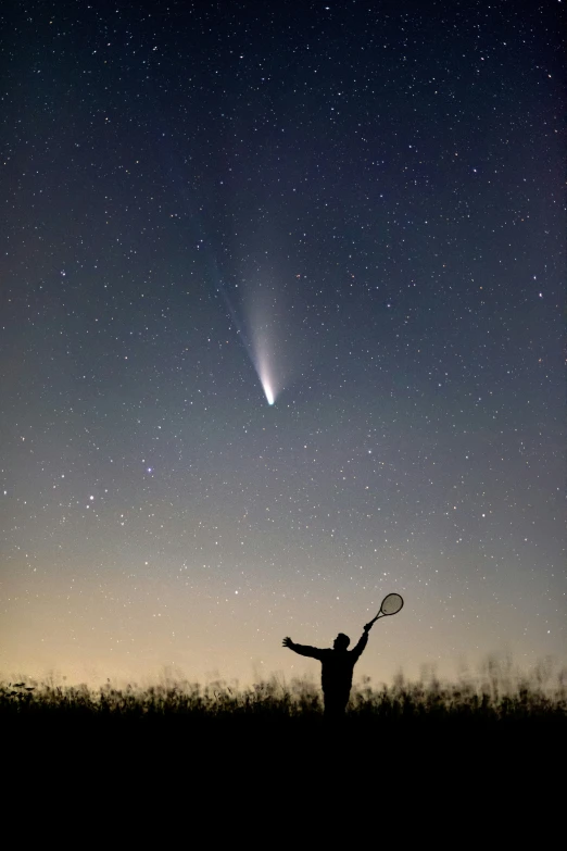 a man with a tennis racket standing next to the moon