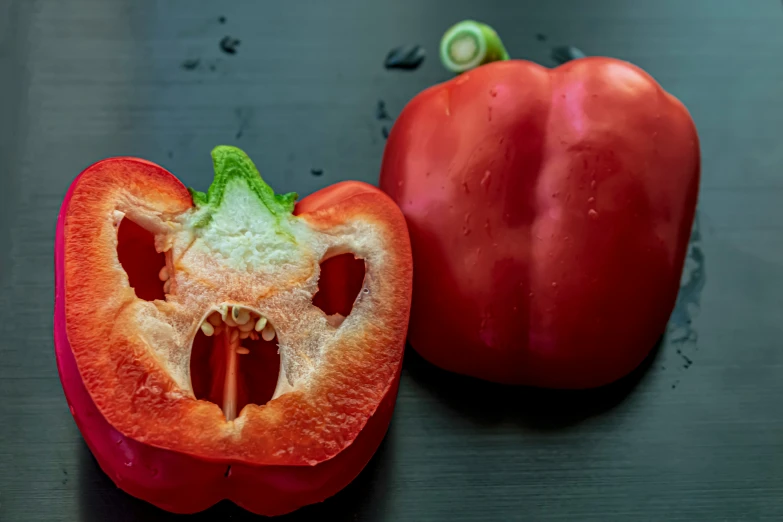 an orange pepper that has been cut open and whole