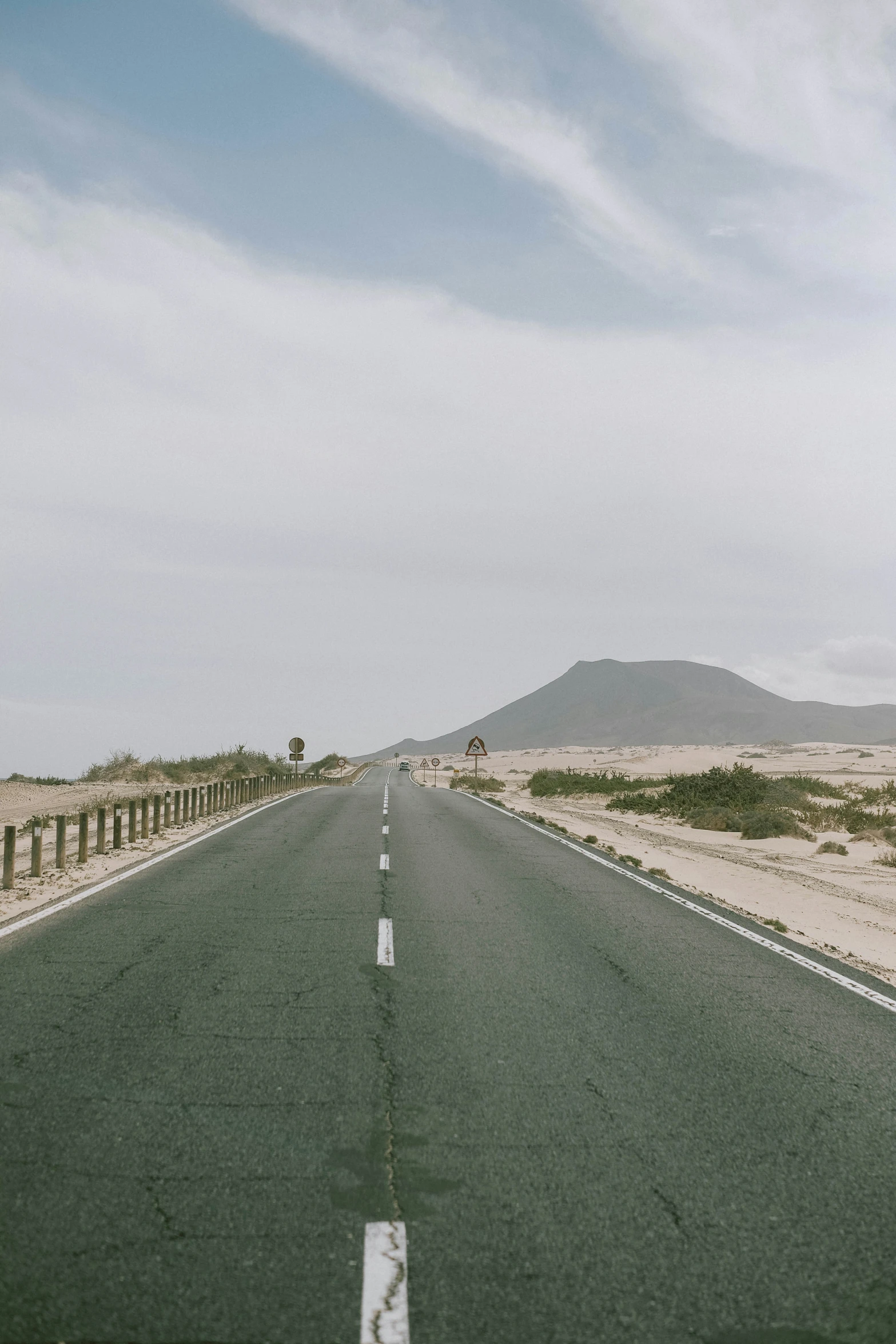 a long empty road on the middle of the desert