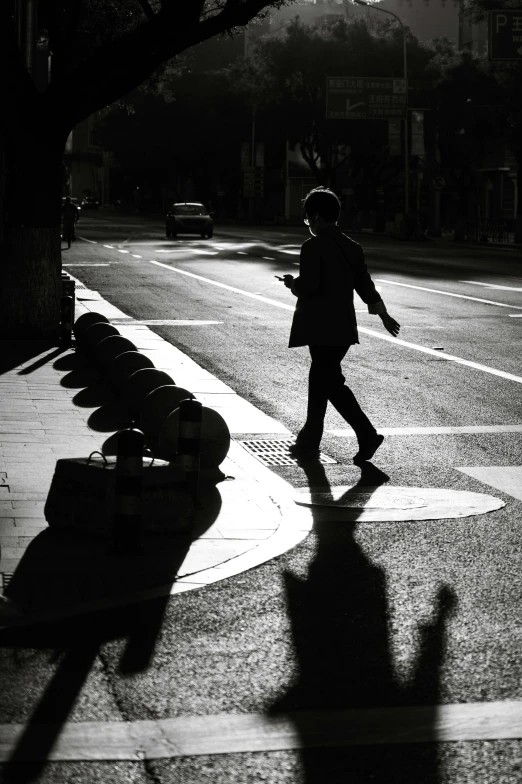 a person crossing the street in front of a crosswalk
