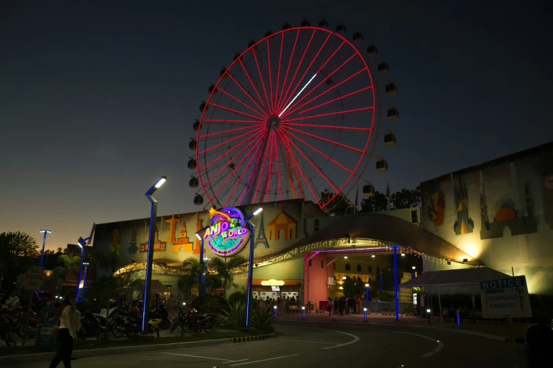 the large wheel is red and illuminated in the night