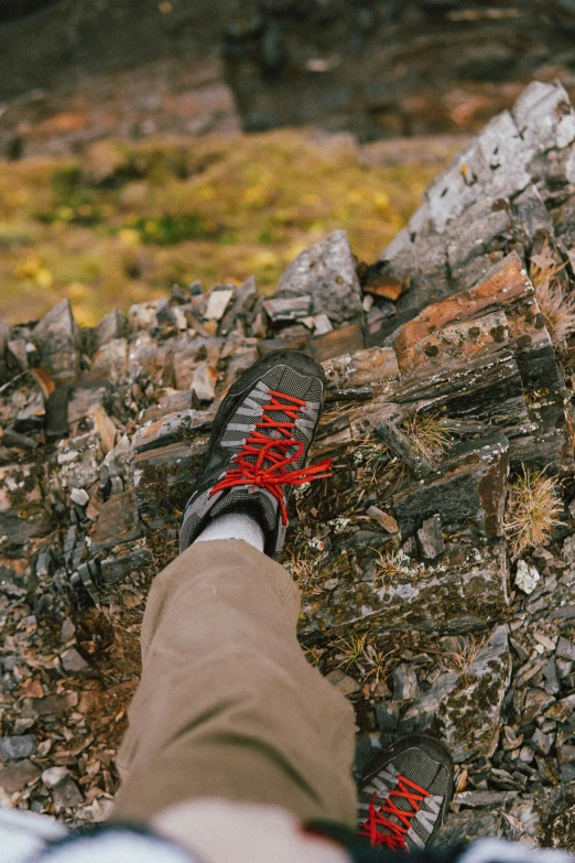 someone is walking through some rocks with their red shoes