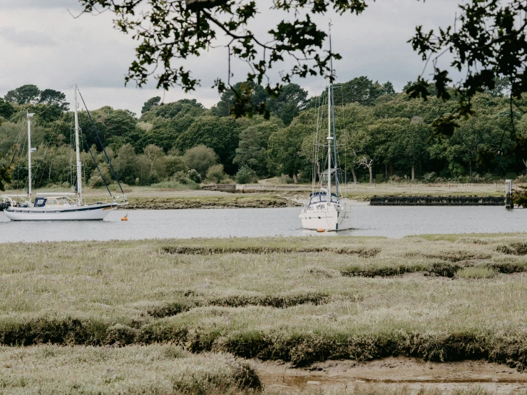 the boats are floating along the water on the shore