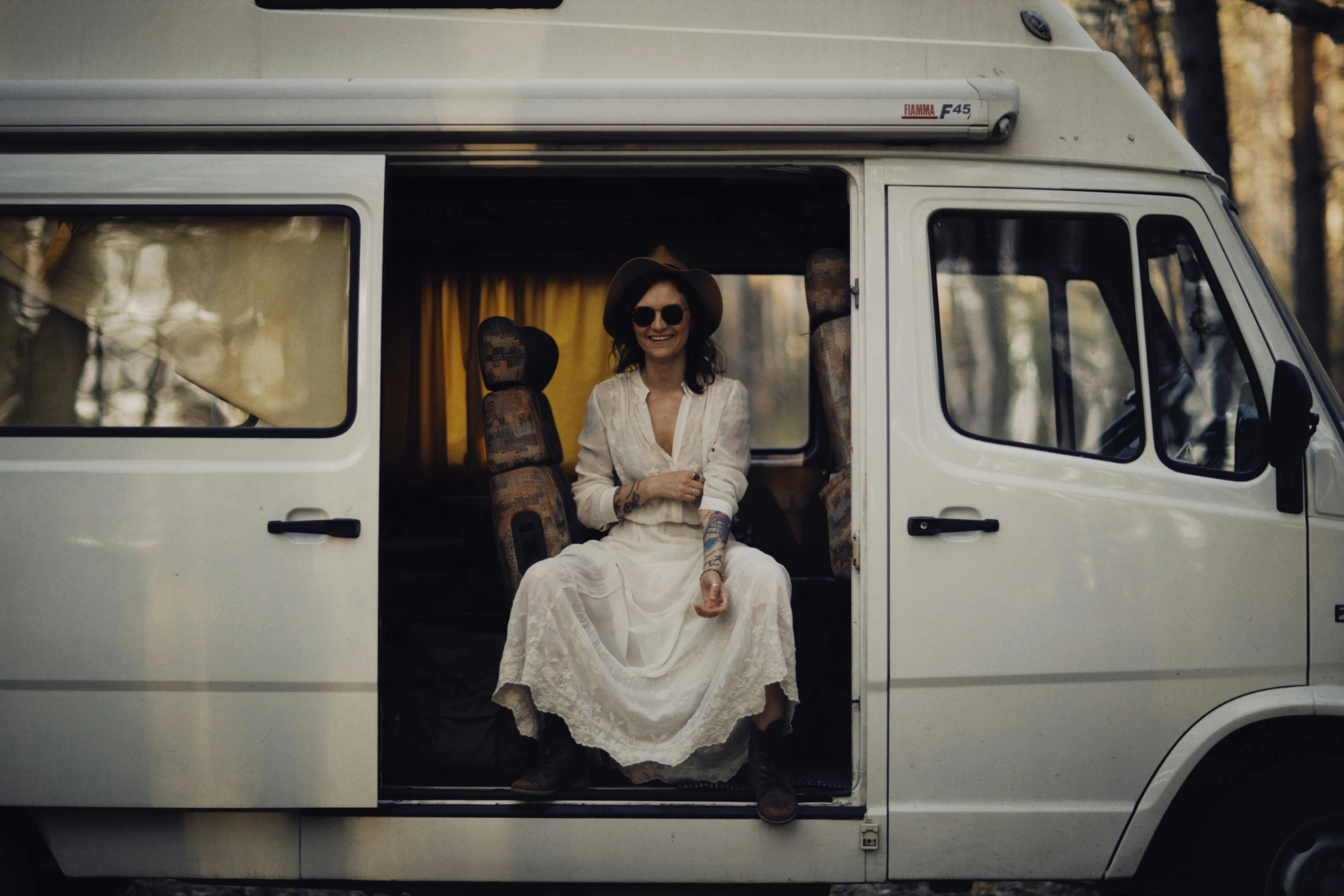 a woman sits in the back of an open van
