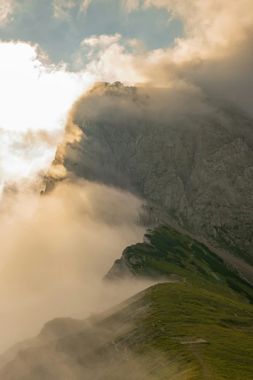 the sun is peeking through the clouds over the mountains