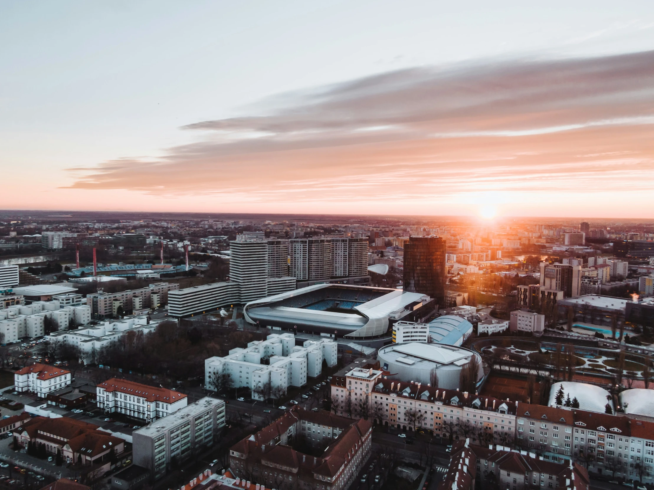 an aerial po of the sun setting behind the stadium