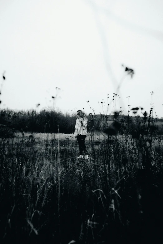 a man standing in a field with weeds