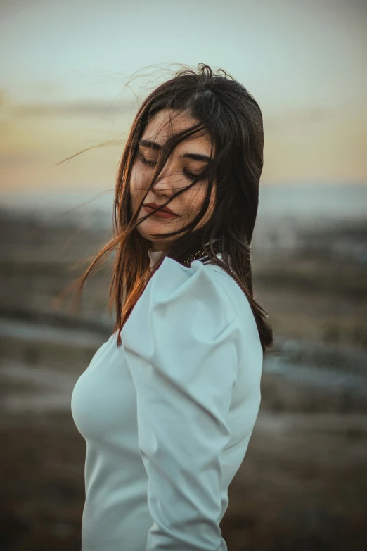 a young woman is posing outdoors at sunset