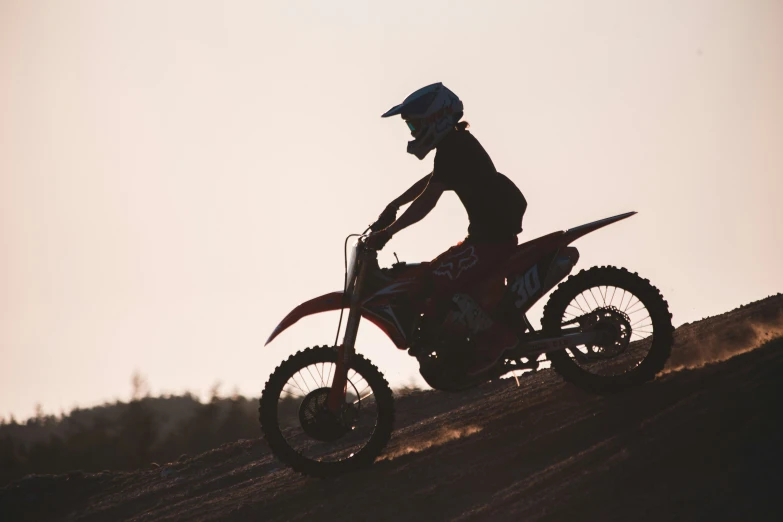 a man riding a dirt bike down a slope