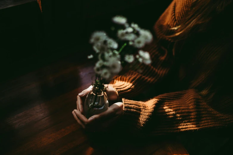 a woman in striped coat holding white flowers