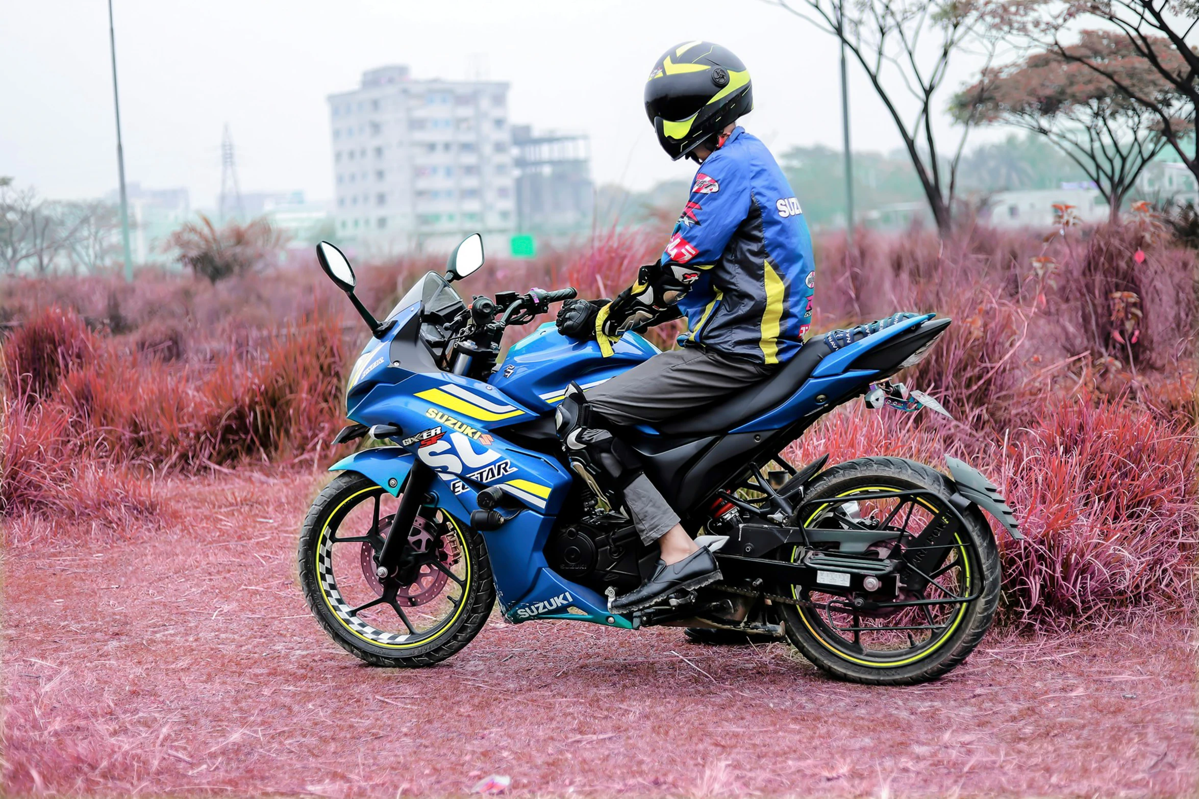 a man riding on the back of a blue motorcycle