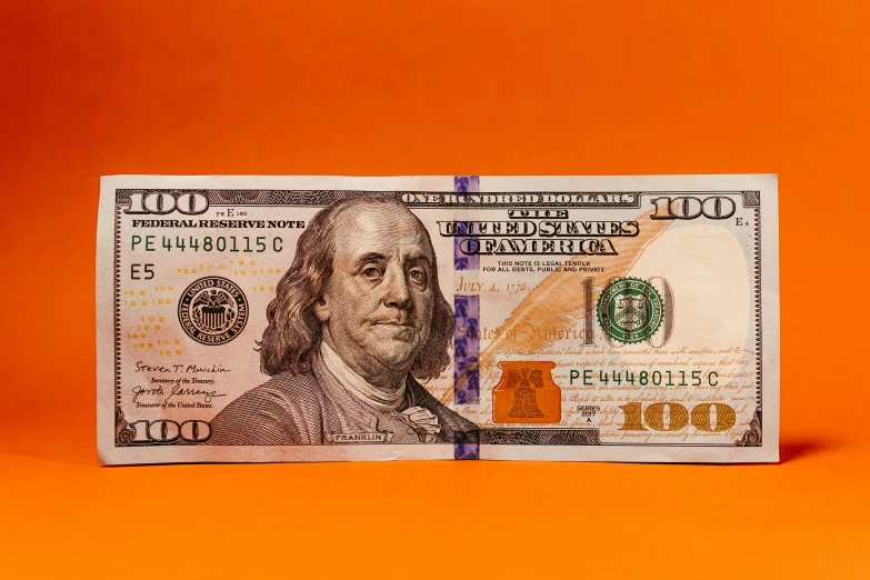 a one dollar bill is placed in the center of an orange background