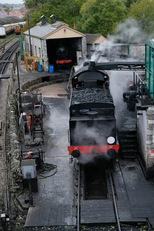 a train sitting on a track near an industrial station