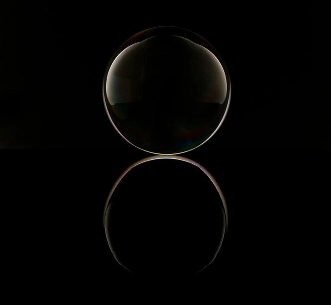 a black circular with reflection and only one object in the middle