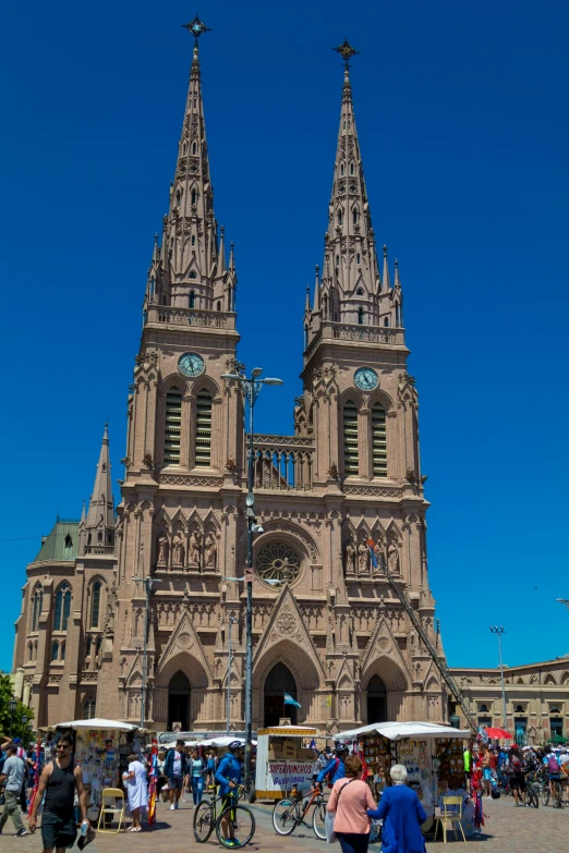 several people walk past two stone towers